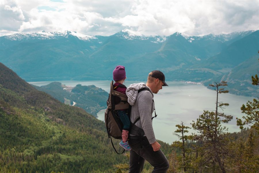 A father carrying a child on a mountain trail