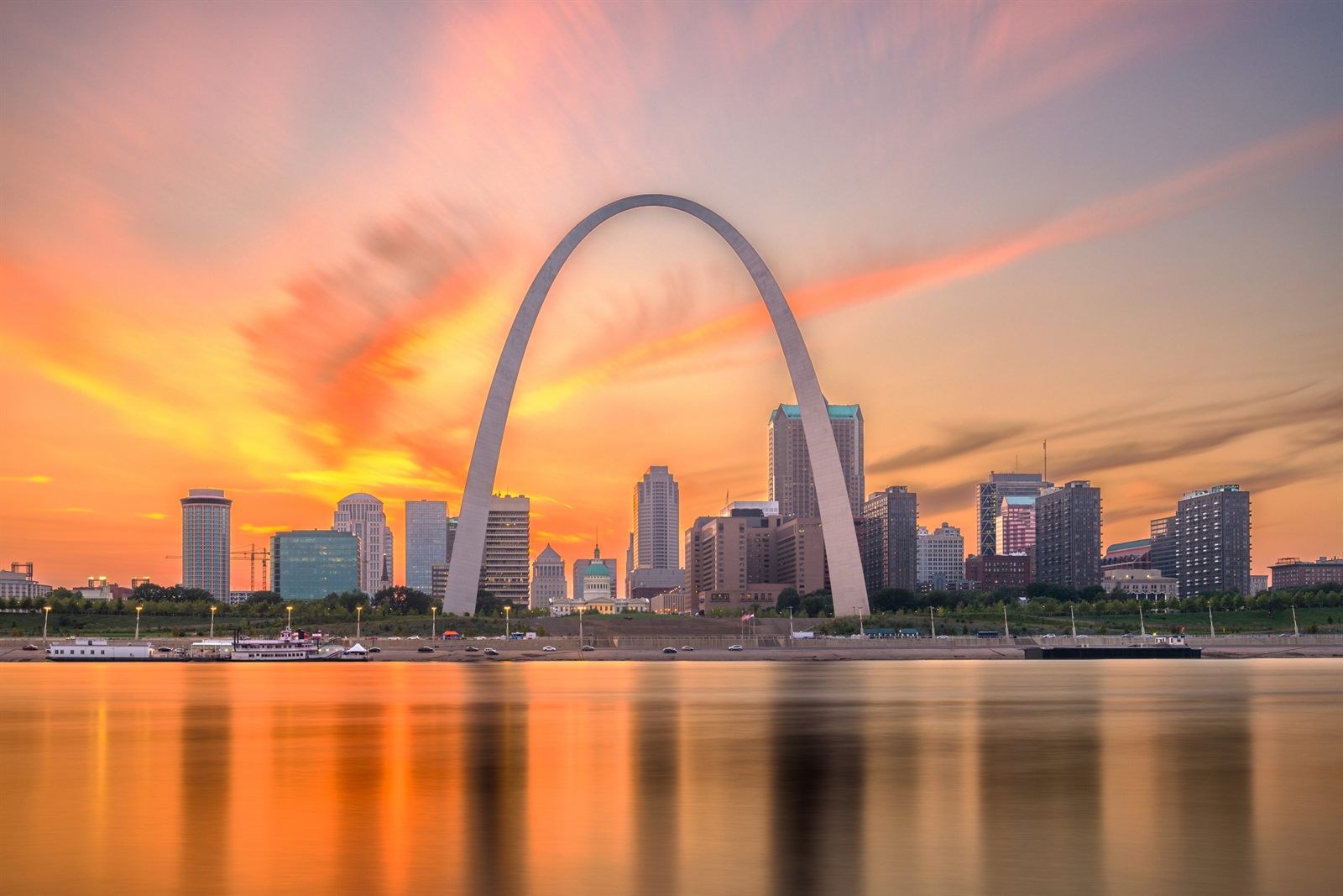 The Gateway Arch and the St. Louis skyline reflected in the Mississippi River at sunset